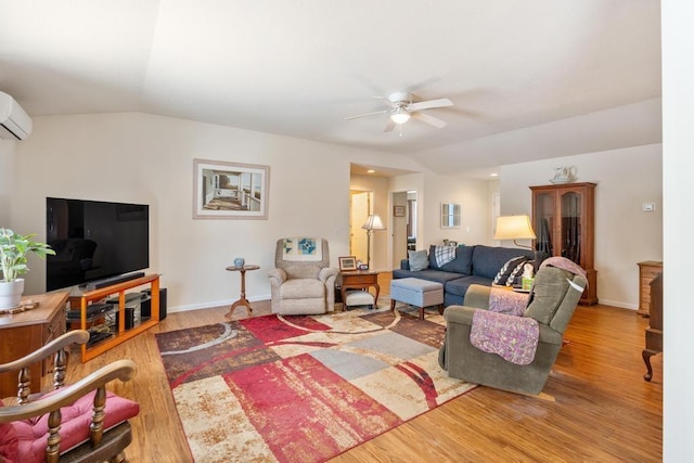 living room with hardwood / wood-style flooring, ceiling fan, and lofted ceiling