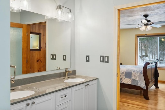 bathroom with wood-type flooring, vanity, and ceiling fan