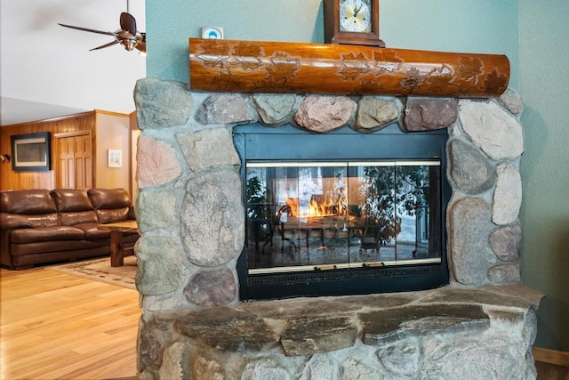 details with a fireplace, wood-type flooring, and ceiling fan