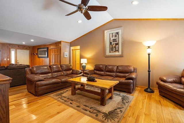 living room with light wood-type flooring, vaulted ceiling, and crown molding