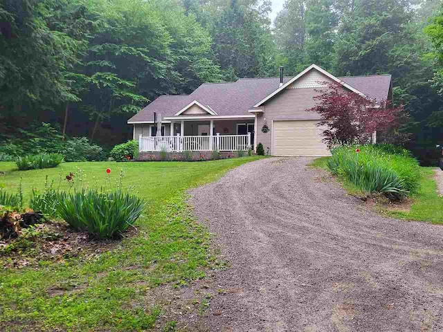 view of front facade featuring covered porch, a garage, and a front lawn