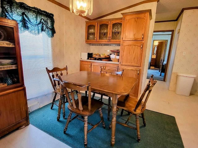 dining room featuring lofted ceiling, crown molding, and a notable chandelier