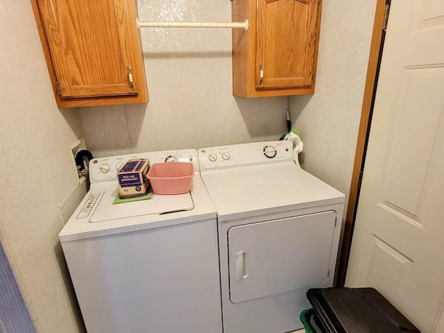 washroom featuring cabinets and independent washer and dryer