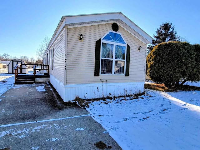 view of snowy exterior with a deck