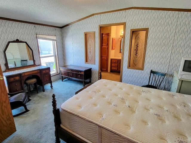 carpeted bedroom with ensuite bathroom, crown molding, and a textured ceiling