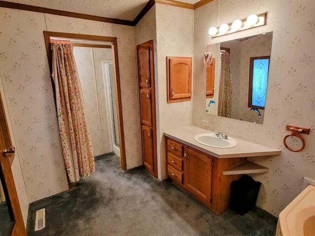 bathroom featuring crown molding, vanity, and a textured ceiling