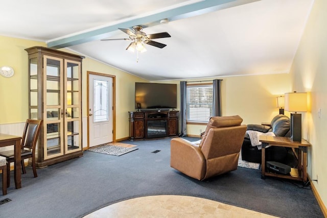 carpeted living room featuring vaulted ceiling with beams, ceiling fan, and a fireplace