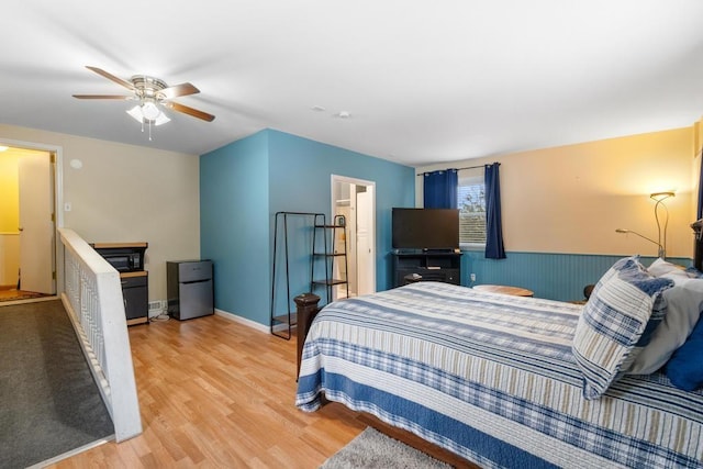 bedroom with ceiling fan, stainless steel fridge, and light hardwood / wood-style flooring