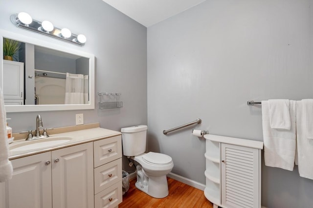 bathroom with vanity, hardwood / wood-style flooring, toilet, and walk in shower