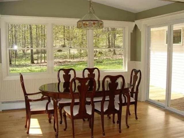 sunroom featuring baseboard heating and vaulted ceiling