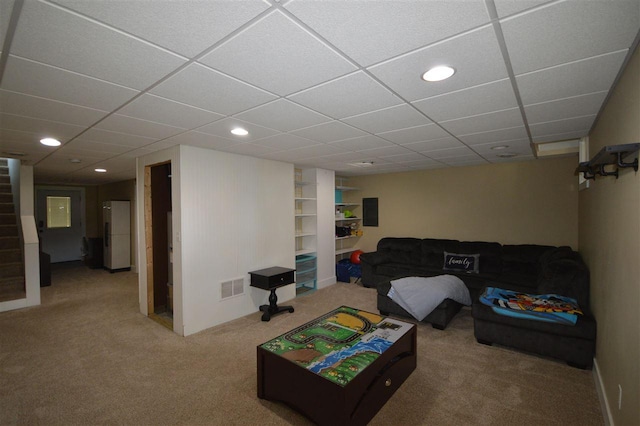 game room featuring a paneled ceiling, built in shelves, and carpet