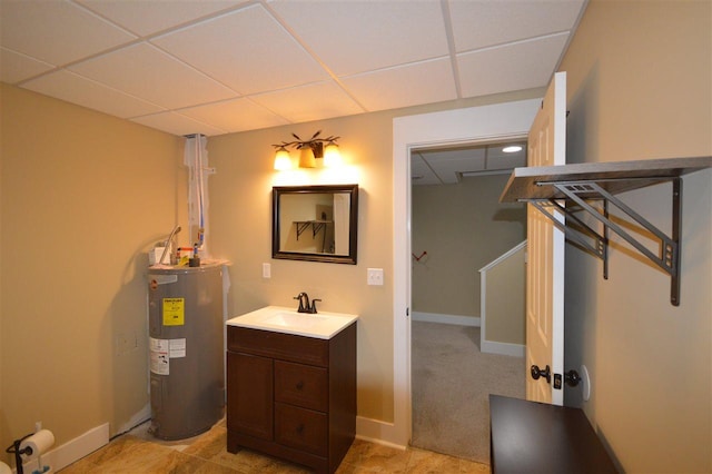 bathroom with vanity, electric water heater, and a drop ceiling