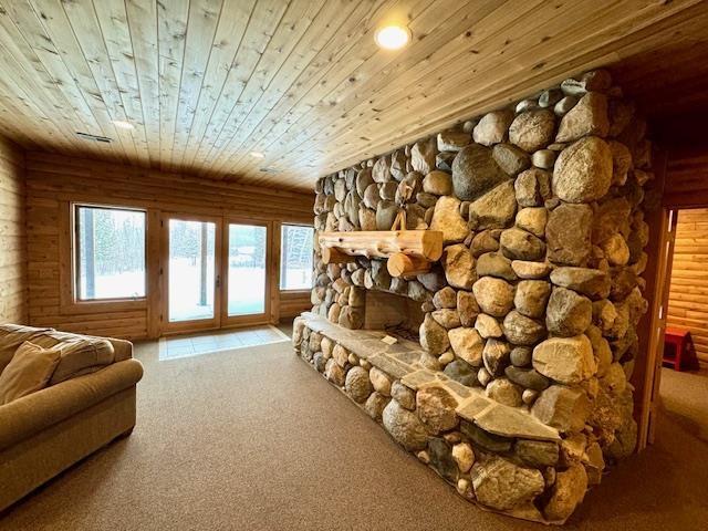 interior space with wooden ceiling, carpet flooring, and a fireplace