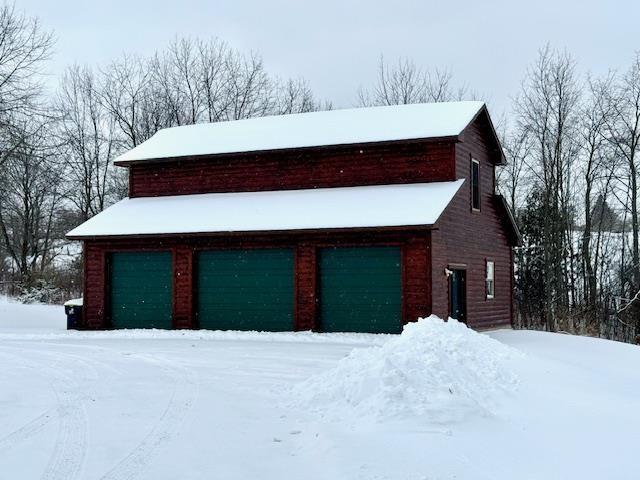 view of front of property featuring a garage and an outdoor structure