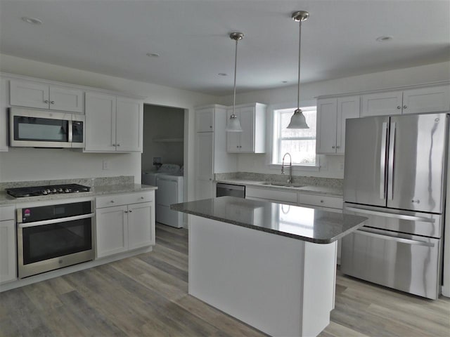 kitchen with white cabinetry, sink, a kitchen island, and appliances with stainless steel finishes