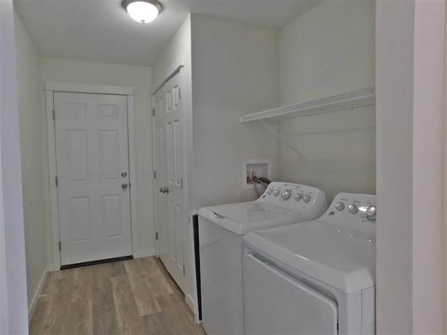 laundry area featuring separate washer and dryer and light hardwood / wood-style flooring