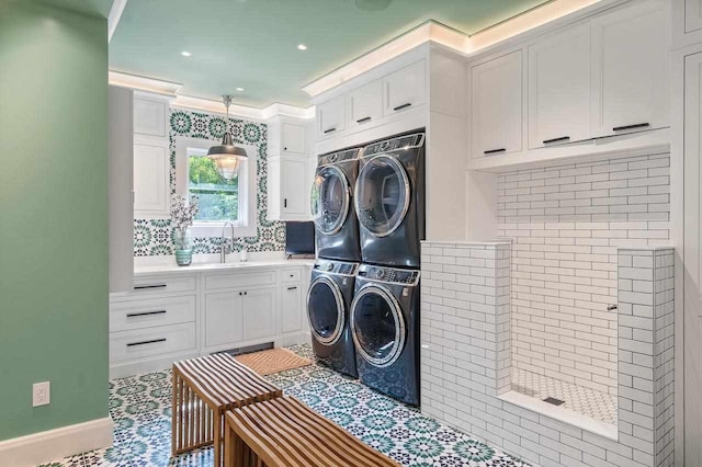 laundry area with cabinets, stacked washing maching and dryer, ornamental molding, sink, and washing machine and clothes dryer