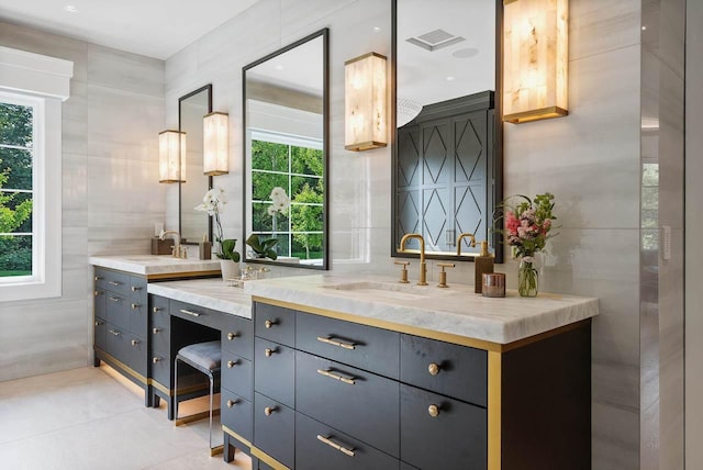 bathroom with tile patterned floors, vanity, and tile walls