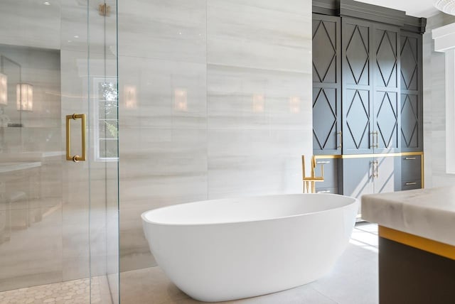 bathroom featuring plus walk in shower, tile patterned flooring, vanity, tile walls, and pool table