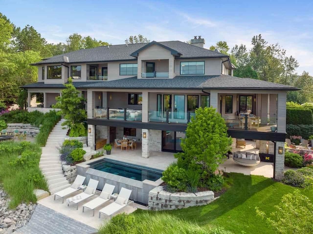 back of house featuring an in ground hot tub and a patio area