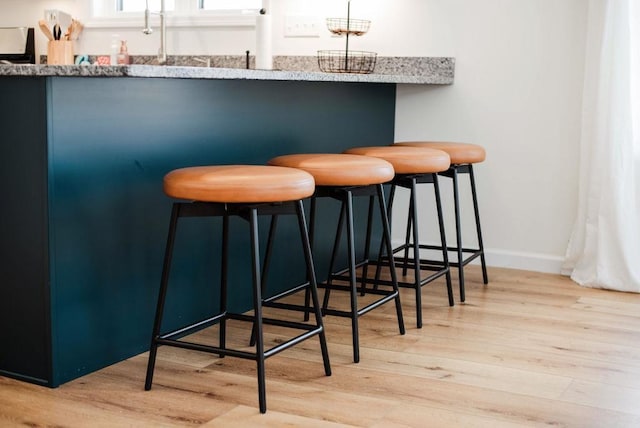 bar with light hardwood / wood-style flooring