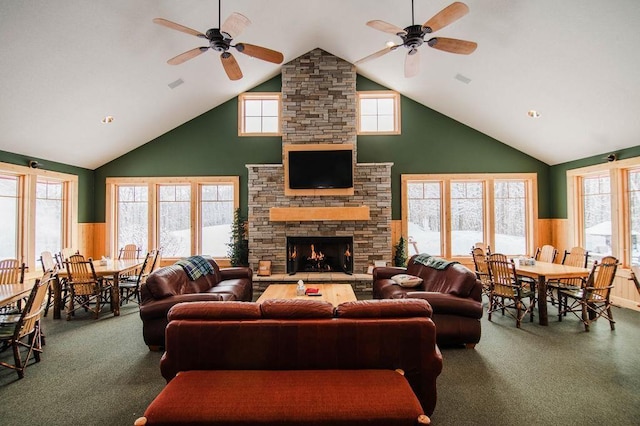 carpeted living room with a wealth of natural light, wood walls, and a fireplace