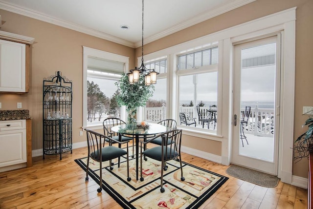 dining area featuring ornamental molding, light hardwood / wood-style flooring, and a chandelier