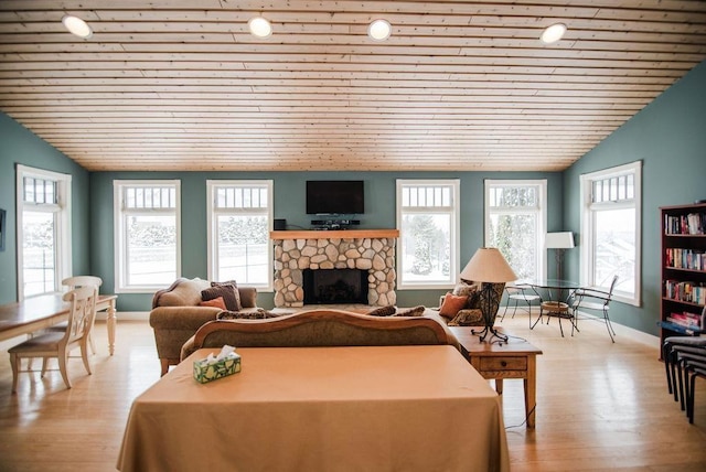 living room featuring wood ceiling, light wood-type flooring, lofted ceiling, and a fireplace