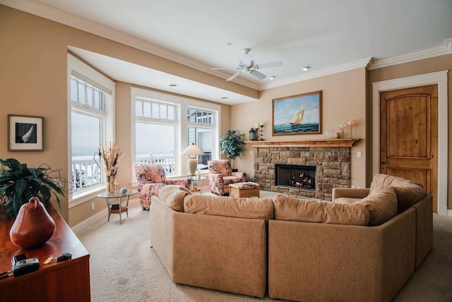 living room with a fireplace, ceiling fan, crown molding, and light colored carpet