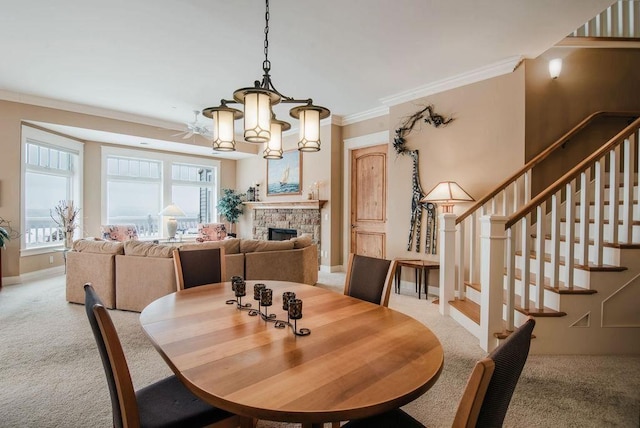 carpeted dining space with a fireplace, an inviting chandelier, and crown molding