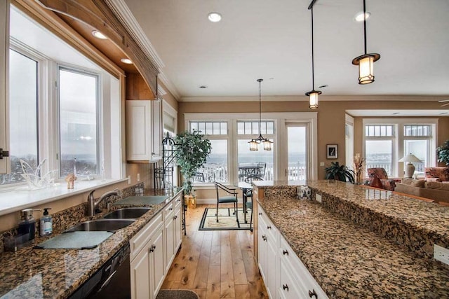 kitchen with dark stone countertops, a chandelier, sink, white cabinetry, and decorative light fixtures