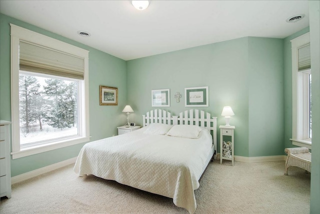 bedroom with light colored carpet and multiple windows