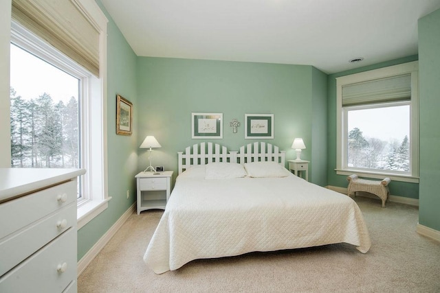 carpeted bedroom featuring multiple windows