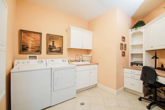 clothes washing area with washer and dryer, cabinets, and sink