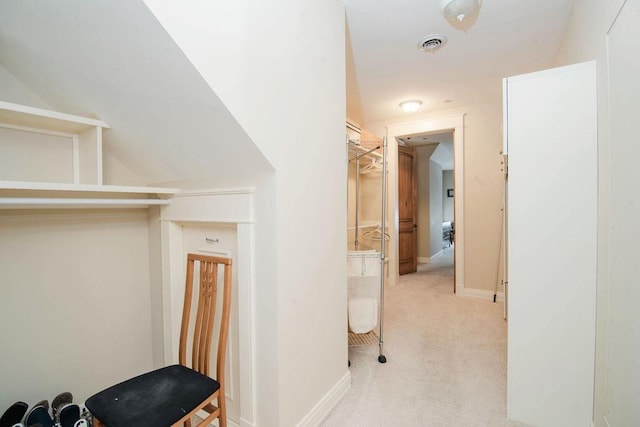 hallway featuring vaulted ceiling and light colored carpet