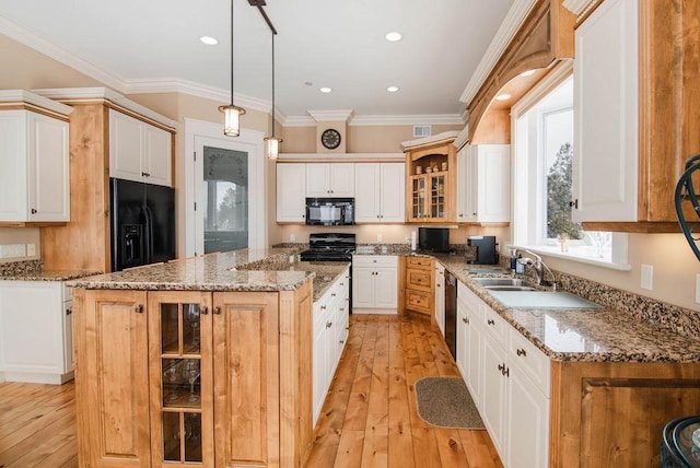 kitchen with ornamental molding, black appliances, hanging light fixtures, and a center island