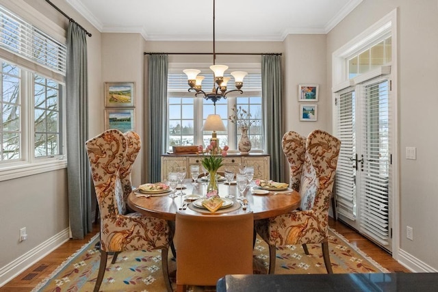 dining space featuring ornamental molding, a healthy amount of sunlight, and a notable chandelier