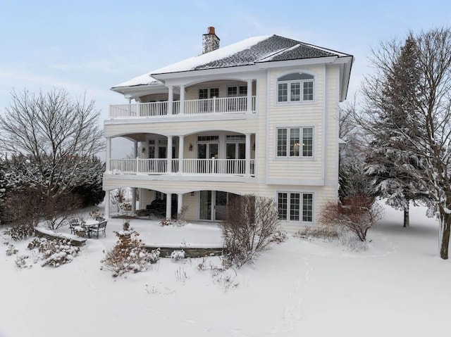 snow covered property with a balcony