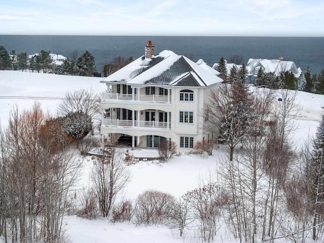 snowy aerial view featuring a water view