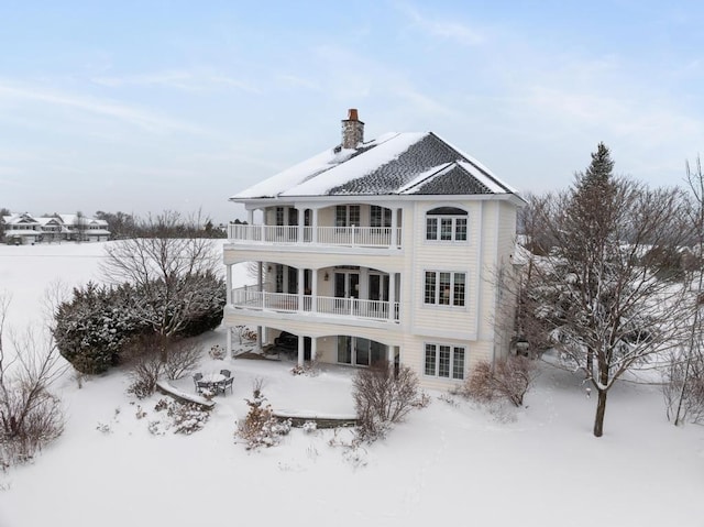 snow covered property with a balcony