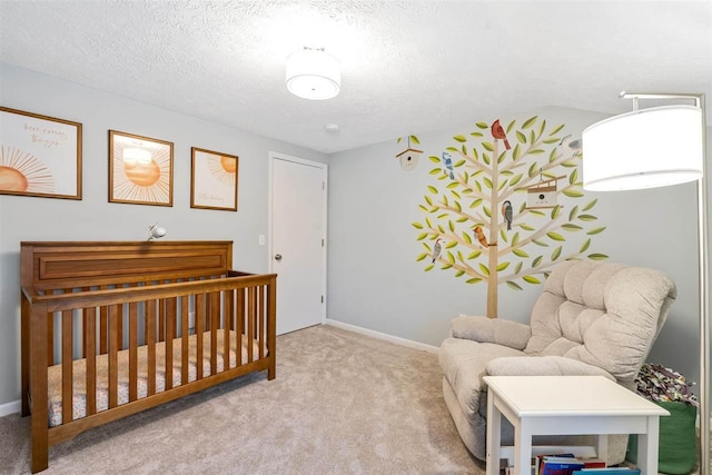 bedroom with a textured ceiling, light colored carpet, and a crib