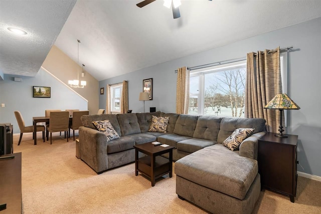 carpeted living room featuring ceiling fan with notable chandelier, a wealth of natural light, and lofted ceiling