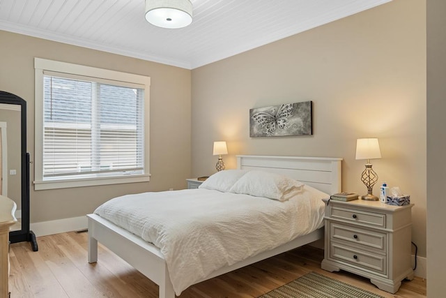 bedroom with light hardwood / wood-style floors and crown molding