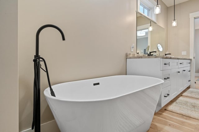 bathroom featuring a tub to relax in, hardwood / wood-style floors, and vanity