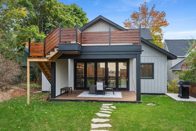 rear view of property with a yard and a wooden deck