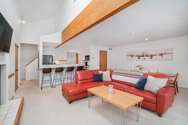 living room with a towering ceiling and light carpet