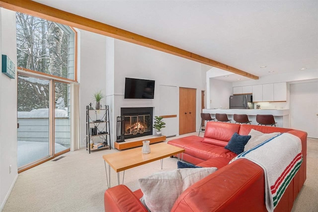 carpeted living room with a towering ceiling and beamed ceiling