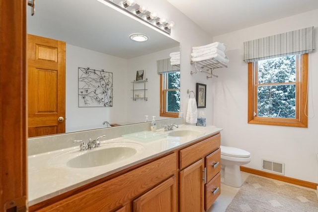 bathroom with toilet, tile patterned floors, and vanity