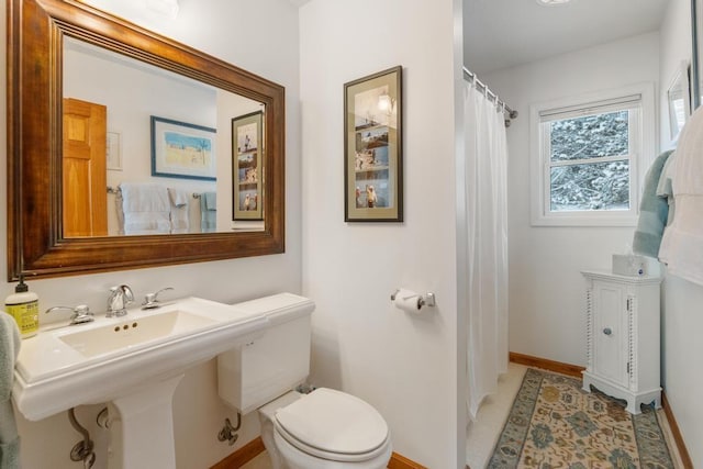 bathroom with toilet, tile patterned flooring, sink, and walk in shower