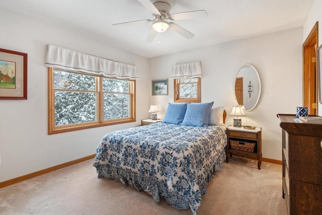 bedroom featuring ceiling fan, light colored carpet, and multiple windows